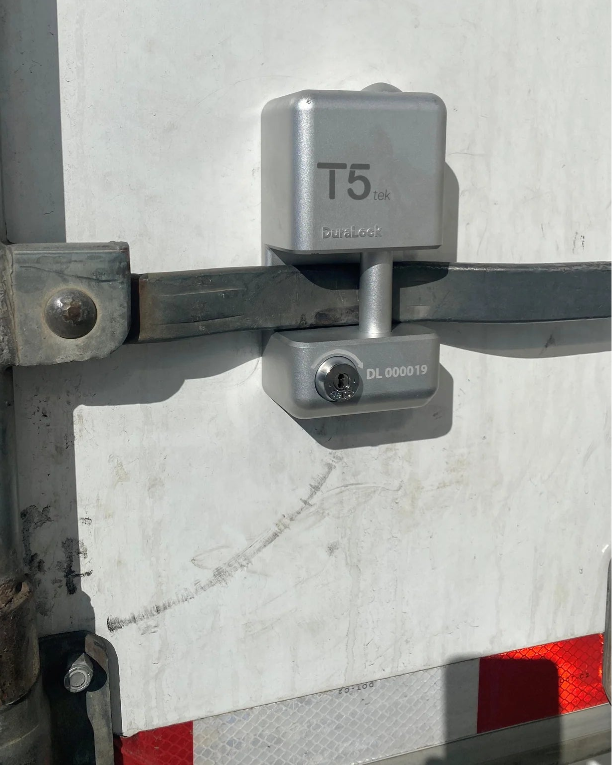 Metal lock mechanism on a vehicle door with visible brand 'T5'.